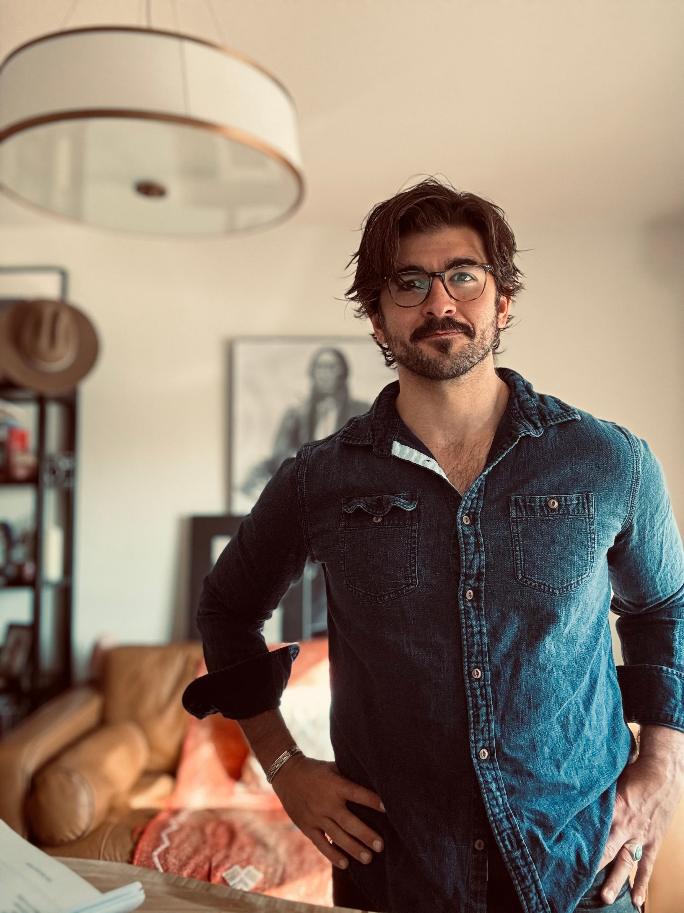 Alex, men's relationship and embodiment coach at Art of Legacy, standing in his Austin, Texas home